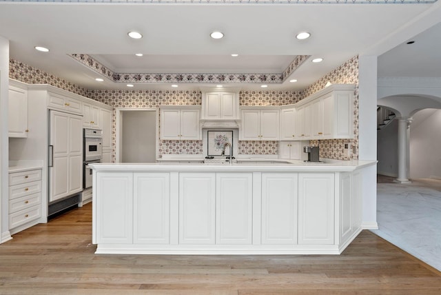 kitchen with white cabinets, kitchen peninsula, and a tray ceiling