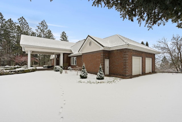 view of snow covered exterior featuring a garage