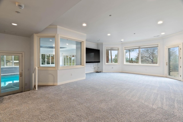 unfurnished living room with a healthy amount of sunlight, carpet floors, and ornamental molding