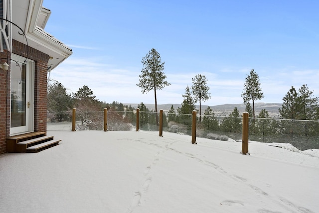 yard covered in snow featuring a mountain view