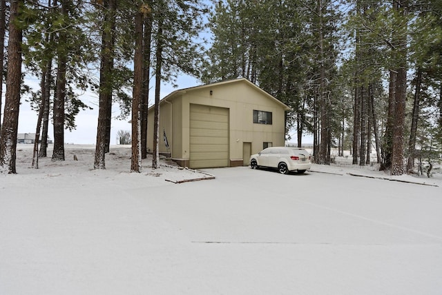 snow covered structure with a garage