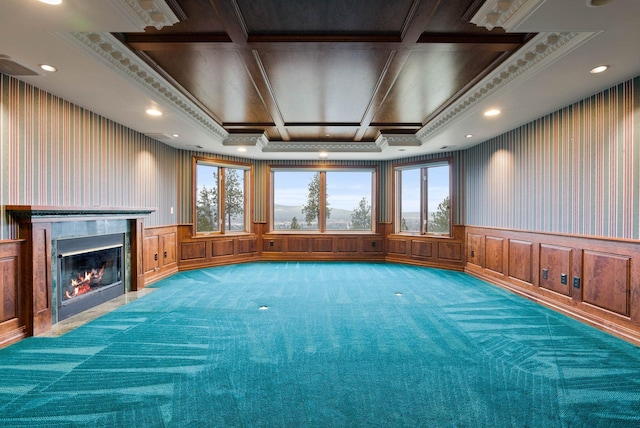 unfurnished living room featuring carpet floors, plenty of natural light, crown molding, and a premium fireplace