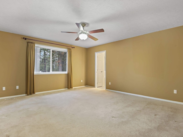 carpeted empty room featuring ceiling fan and a textured ceiling