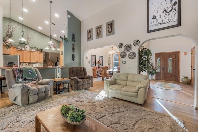 living room featuring light wood-type flooring and a towering ceiling