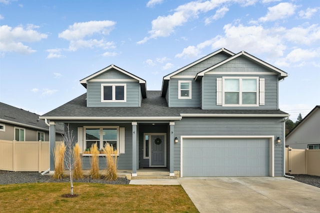 view of front of house with a garage, covered porch, and a front yard