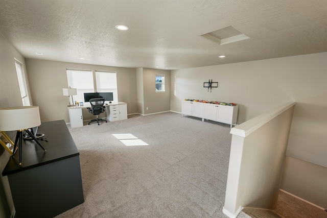 office space featuring light carpet and a textured ceiling