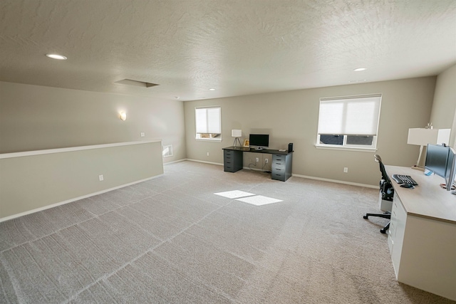 home office with light colored carpet and a textured ceiling