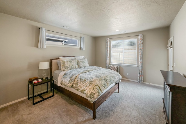 carpeted bedroom featuring multiple windows and a textured ceiling