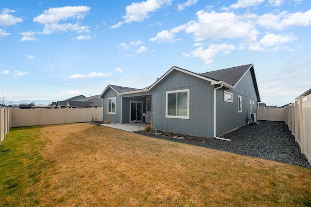 back of house with a patio and a lawn