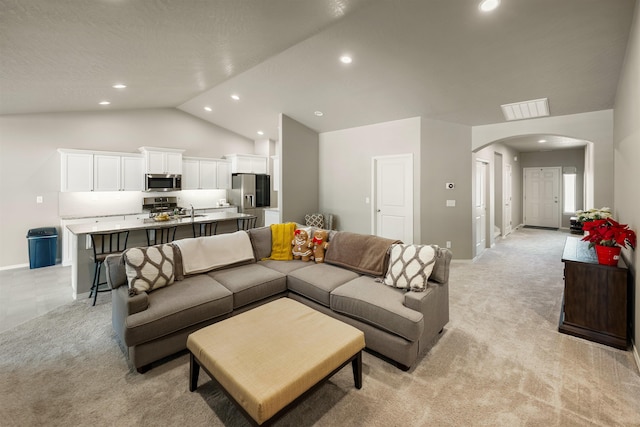 living room with vaulted ceiling and light carpet