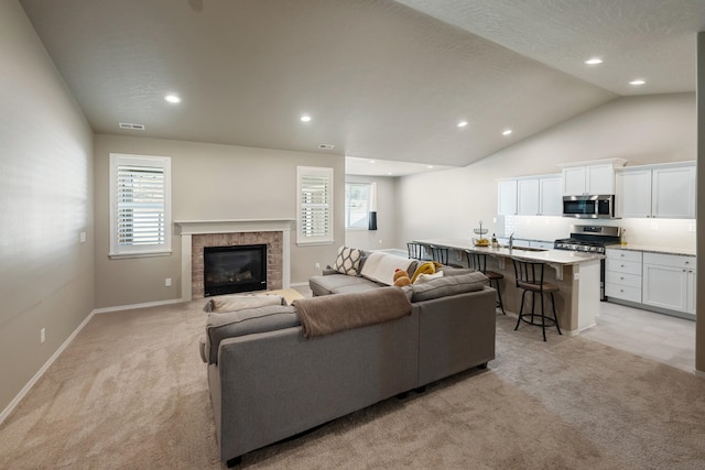 carpeted living room featuring sink, plenty of natural light, and a textured ceiling