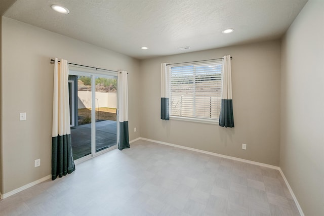 unfurnished room with a textured ceiling