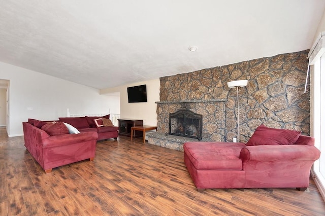 living room featuring hardwood / wood-style flooring and a stone fireplace