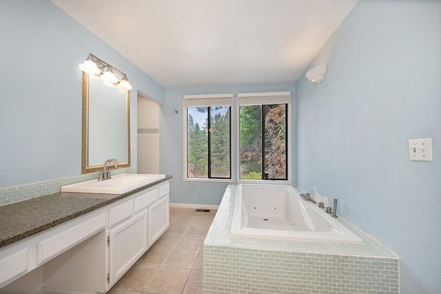 bathroom featuring vanity, a relaxing tiled tub, and tile patterned flooring