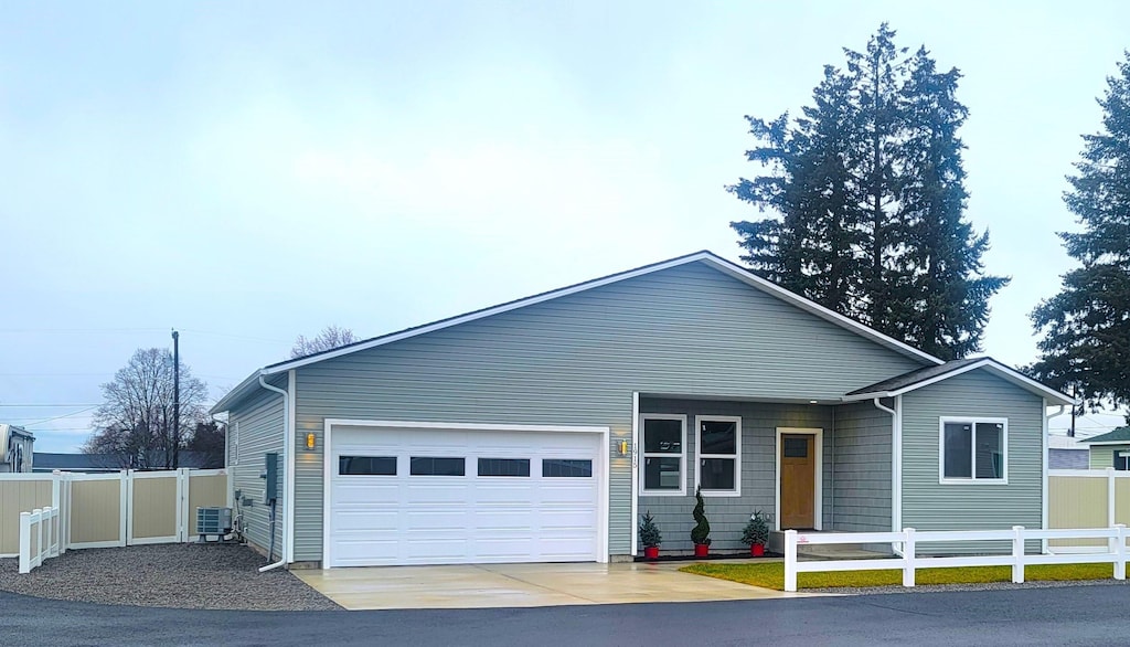 view of front of house featuring a garage and central air condition unit