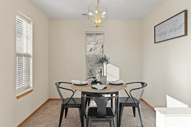 dining room with a notable chandelier and carpet flooring