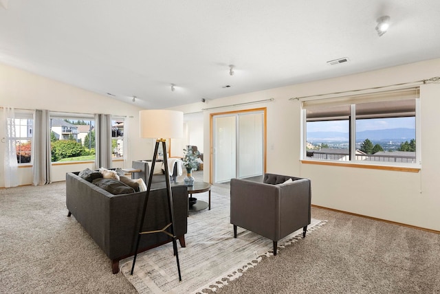 carpeted living room featuring lofted ceiling and plenty of natural light