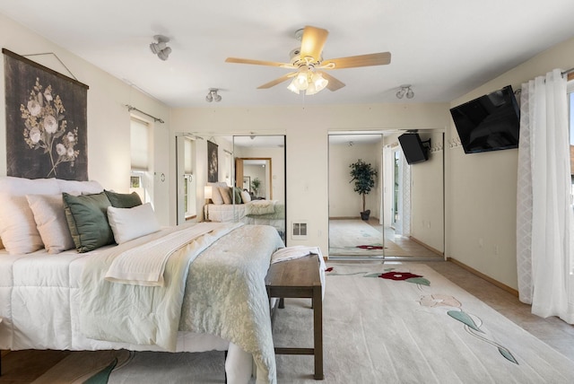 bedroom with multiple closets and ceiling fan