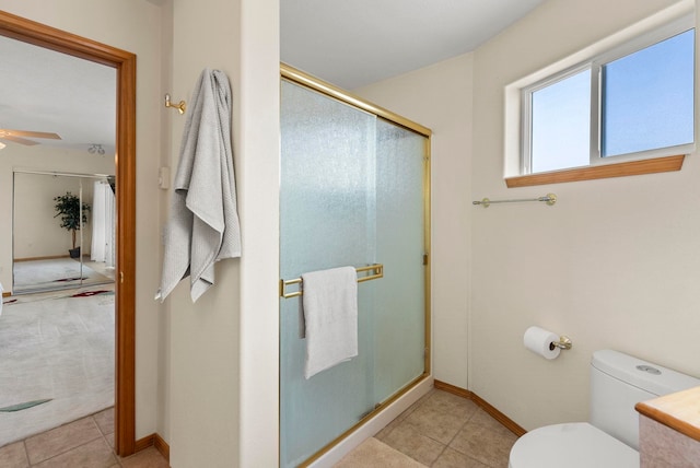 bathroom with ceiling fan, toilet, and an enclosed shower