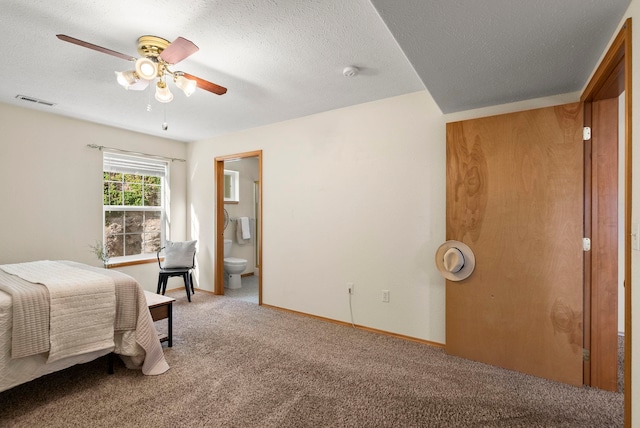 bedroom featuring ceiling fan, connected bathroom, carpet floors, and a textured ceiling