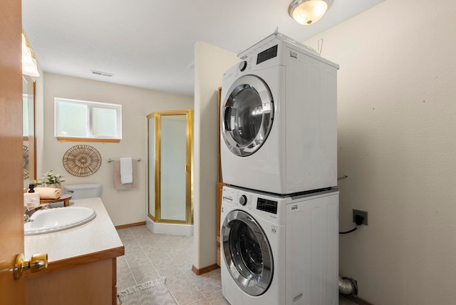 clothes washing area featuring sink and stacked washer / dryer