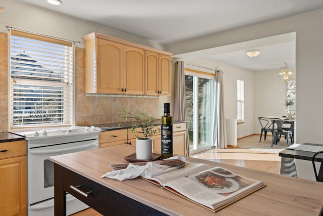 kitchen featuring backsplash, white electric stove, a chandelier, and light brown cabinets