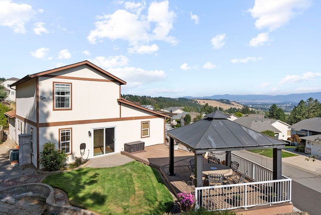 back of property with a gazebo, central AC, a deck with mountain view, and a lawn