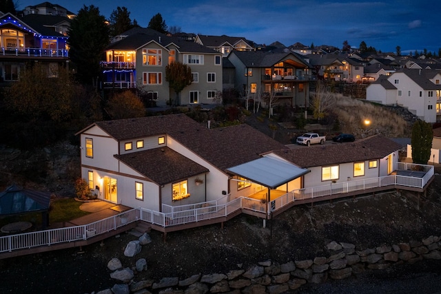 back house at dusk with a gazebo