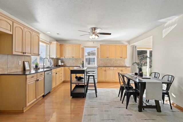 kitchen with tasteful backsplash, dishwasher, sink, light hardwood / wood-style floors, and light brown cabinets