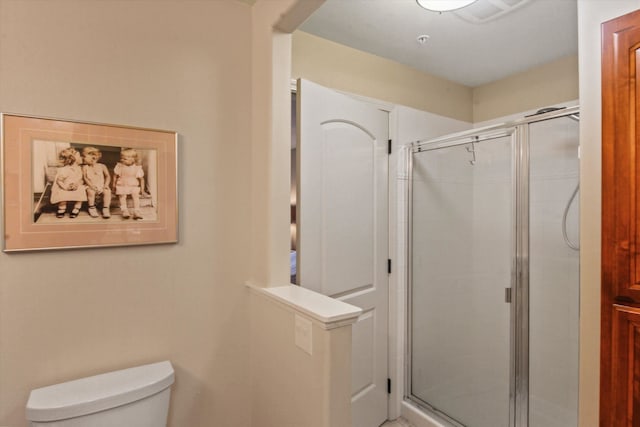 bathroom with toilet and a shower with door