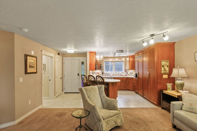 living room featuring sink, light carpet, and a textured ceiling