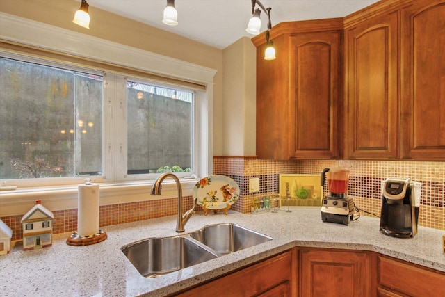 kitchen featuring light stone countertops, sink, and decorative backsplash