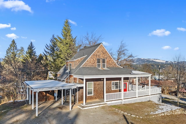 view of front of property with a carport, a mountain view, and covered porch