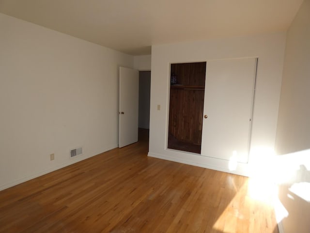 unfurnished bedroom with a closet and light wood-type flooring