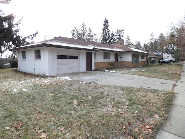 single story home featuring a garage and a front lawn