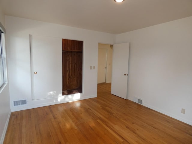 unfurnished bedroom featuring light hardwood / wood-style floors and a closet