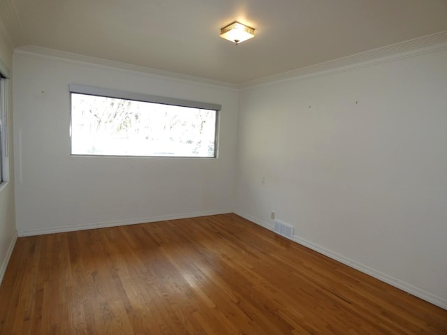 empty room with crown molding and wood-type flooring