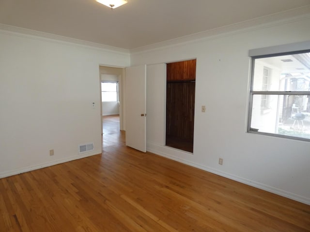 empty room featuring crown molding and hardwood / wood-style floors