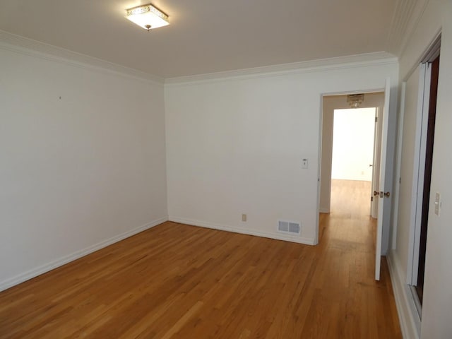 empty room with crown molding and hardwood / wood-style floors