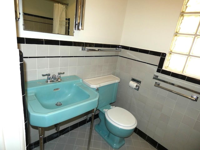 bathroom featuring tile walls, sink, tile patterned floors, and toilet