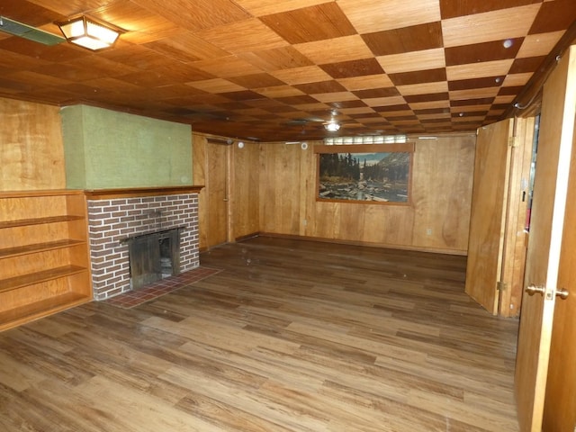 basement featuring wood ceiling, a fireplace, wood-type flooring, and wooden walls