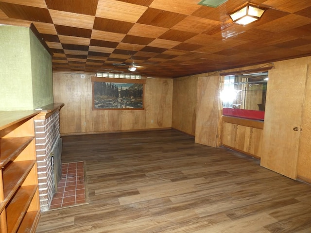 basement featuring a fireplace, wooden ceiling, dark hardwood / wood-style flooring, and wood walls