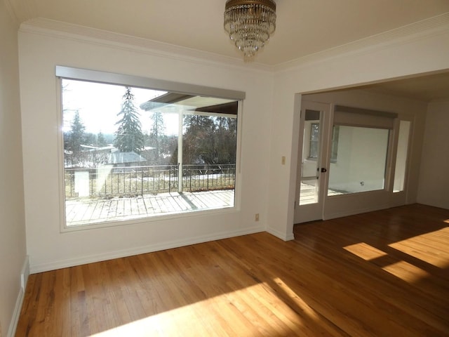 interior space with hardwood / wood-style flooring, ornamental molding, and a chandelier