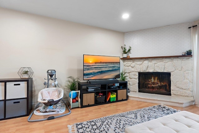 living room featuring hardwood / wood-style floors and a stone fireplace