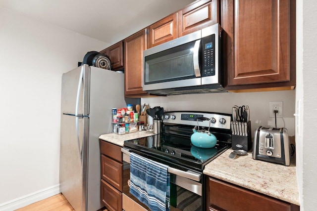 kitchen with appliances with stainless steel finishes and light wood-type flooring