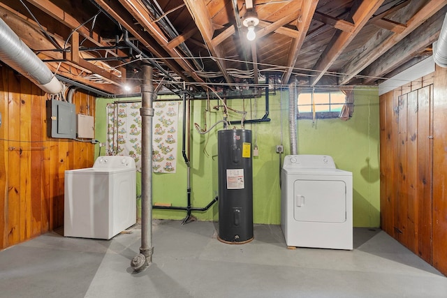 basement with electric panel, electric water heater, washer and dryer, and wood walls