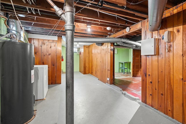 basement with washer / dryer, electric water heater, and wood walls