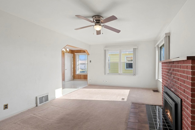 unfurnished living room featuring ceiling fan, light carpet, and a fireplace