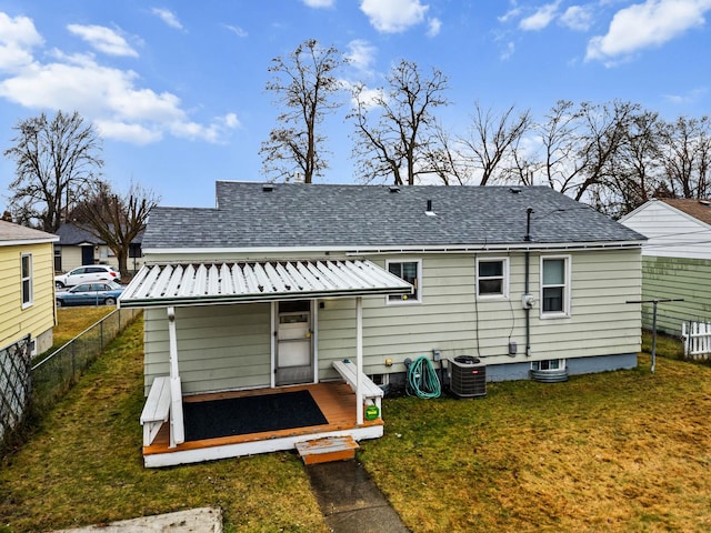 rear view of property featuring a yard and central AC unit