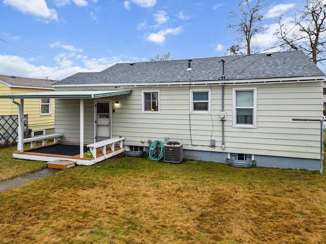 back of property with a yard and central AC